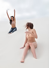 Two stunning young models are having some fun outdoors while posing in the snow with joy