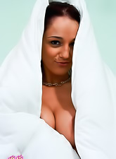 Hot brunette chick Nikki Sims strips on the bed and shows her bouncy big jugs.