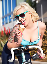 Tattooed blonde babe Lynn Pops strips and teases us with her fuckable body.