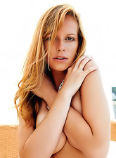 Seductive busty blonde Carmen Gemini strips on her bed and shows her shaved cunt.