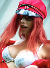 Lusty redhead bimbo Gabrielle Lupin takes off her bra and shows her round hooters.