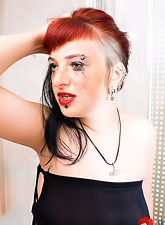 Horny gothic teen babe Red Maggie applies make up in the toilet in a kinky way.