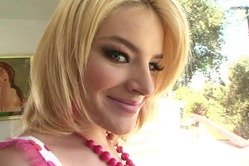 Stretchy blonde babe gets her pink panties move to the side for a peek at her shaved pussy