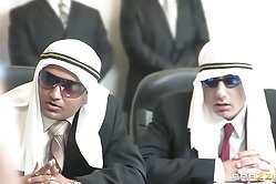 Talented brunette kneels between two well-hung dudes to take their hard dicks into her throat